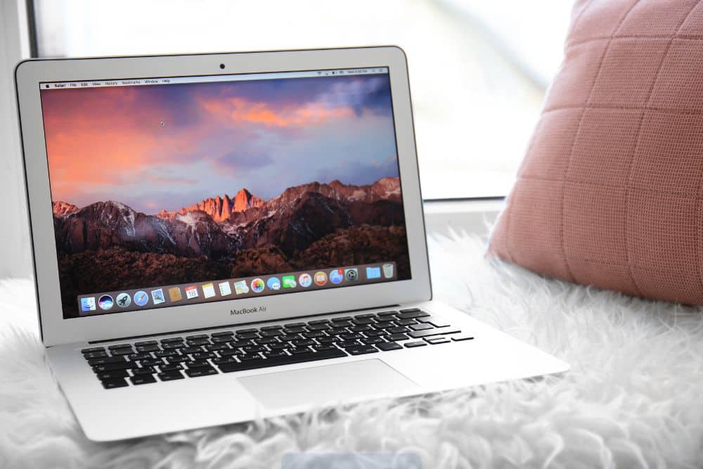 Persona revisando un MacBook usado con atención en escritorio